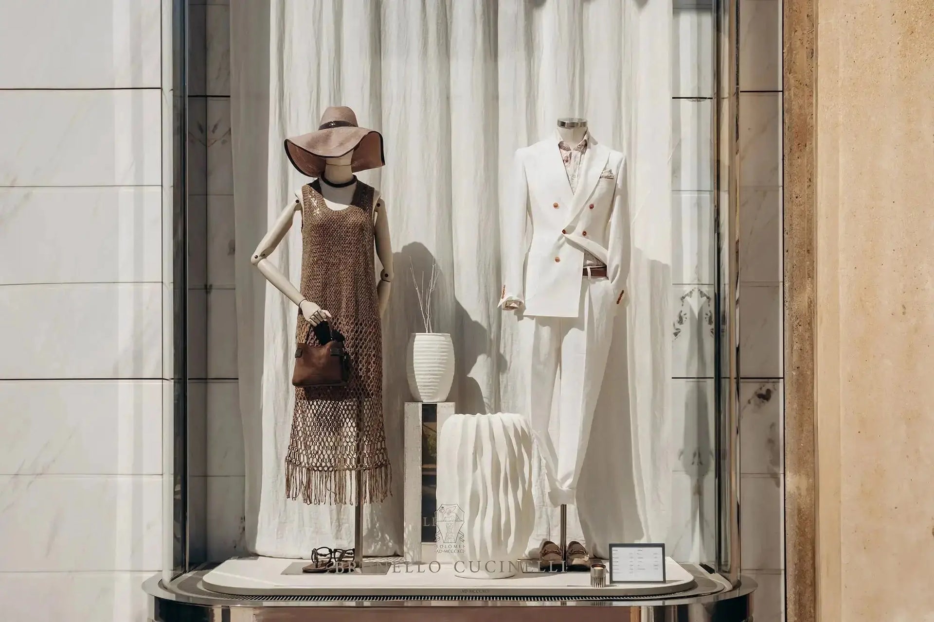 Brown woven fringe handbag on mannequin in luxury store window