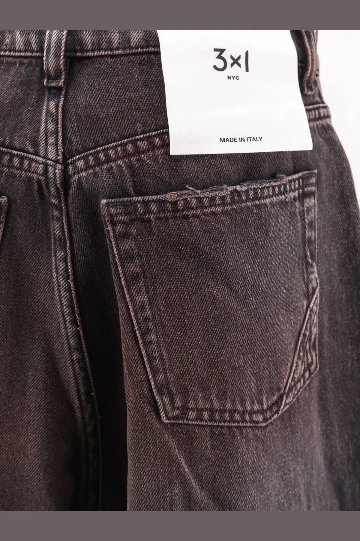 Dark gray denim jeans with distressed pocket and white 3x1 nyc made in italy label for women skater style