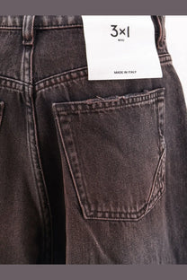 Dark gray denim jeans with distressed pocket and white 3x1 nyc made in italy label for women skater style