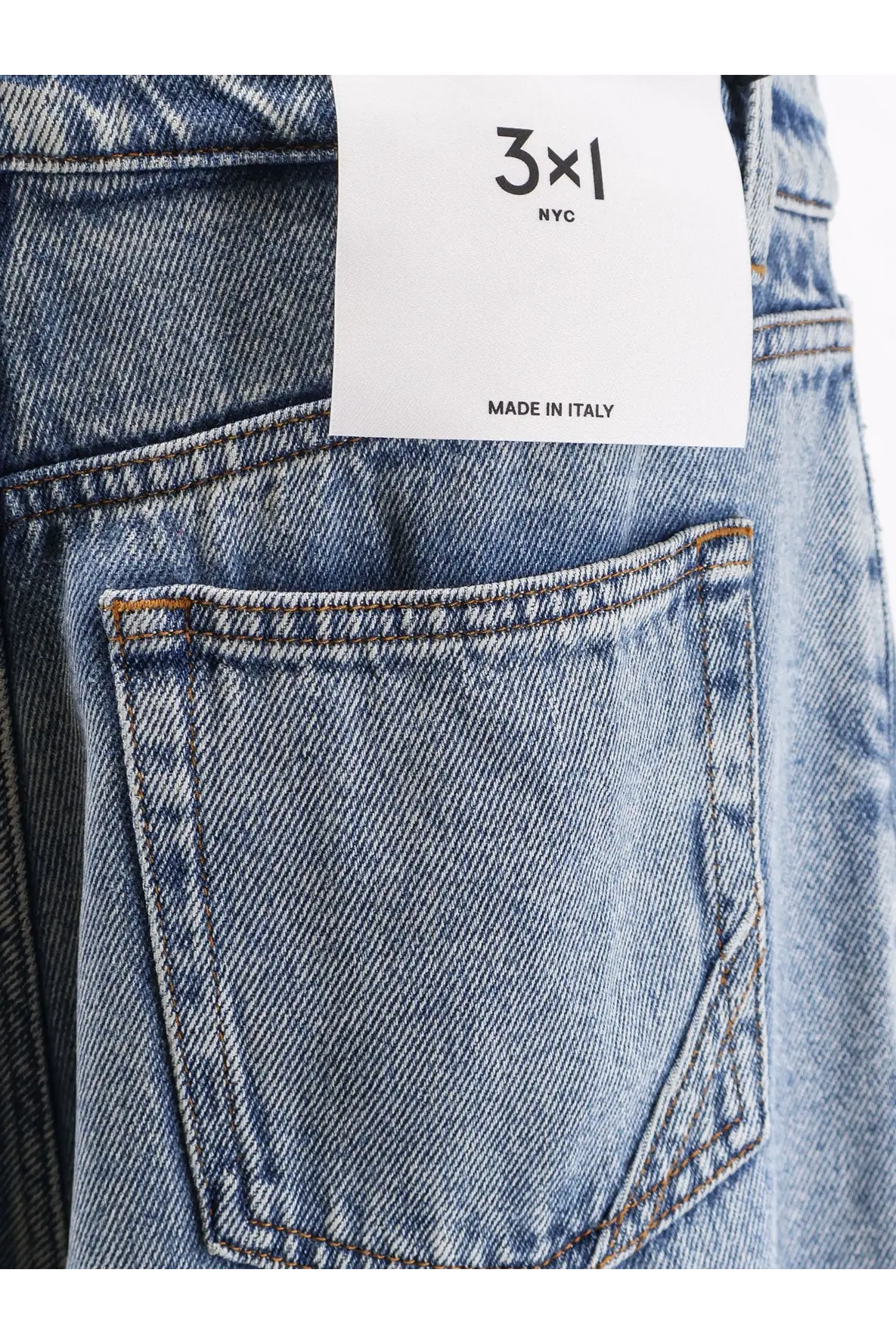 Back side of light-wash denim 3x1 women’s skater boyfriend jeans with classic pocket, contrasting stitching, and white label made in italy