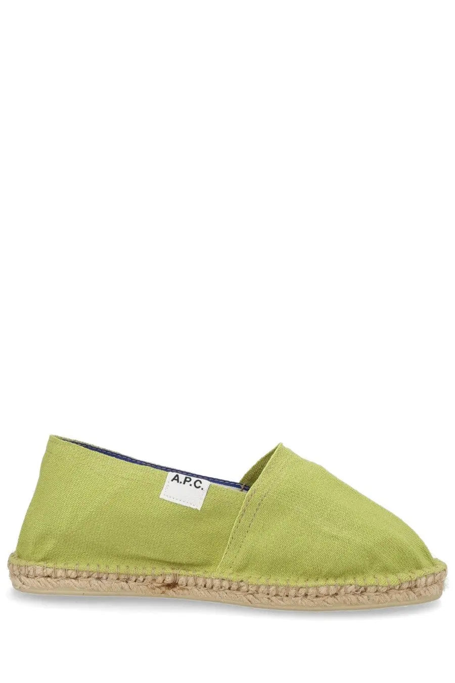 A lime green canvas espadrille slip-on shoe with a woven jute sole and a white a.p.c. label in tela green