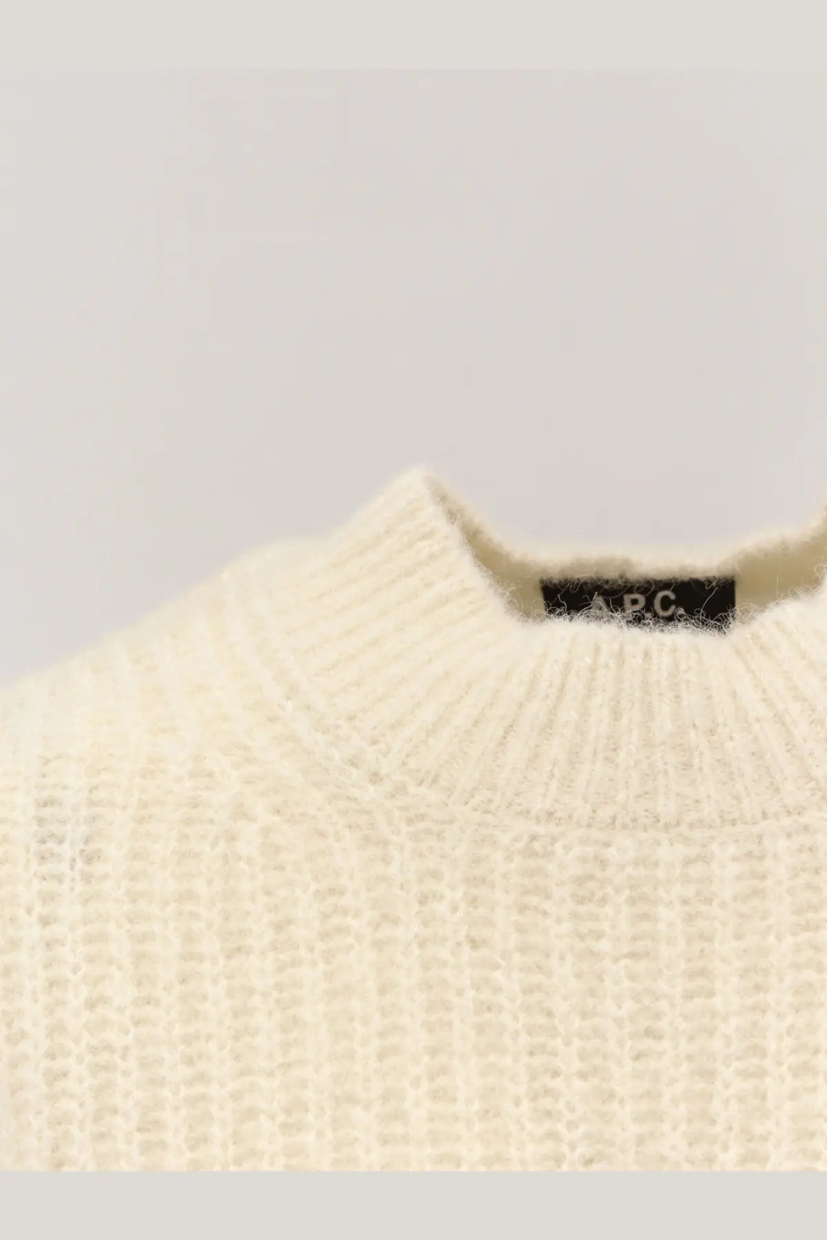 A.P.C women’s cream-colored wool blend sweater with ribbed knit texture and black brand tag at the neckline