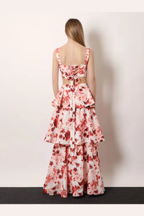 A woman wearing actualee women’s pink cotton and linen blend two-piece floral dress with tiered ruffles at the waist