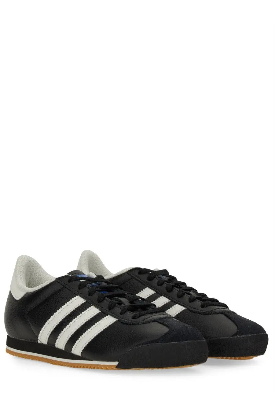 Adidas men’s kick sneaker black with three white stripes black laces and gum-colored rubber sole visible from front