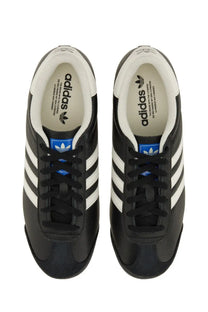 Adidas men’s kick sneaker in black with white three stripes and blue branding accents for casual wear