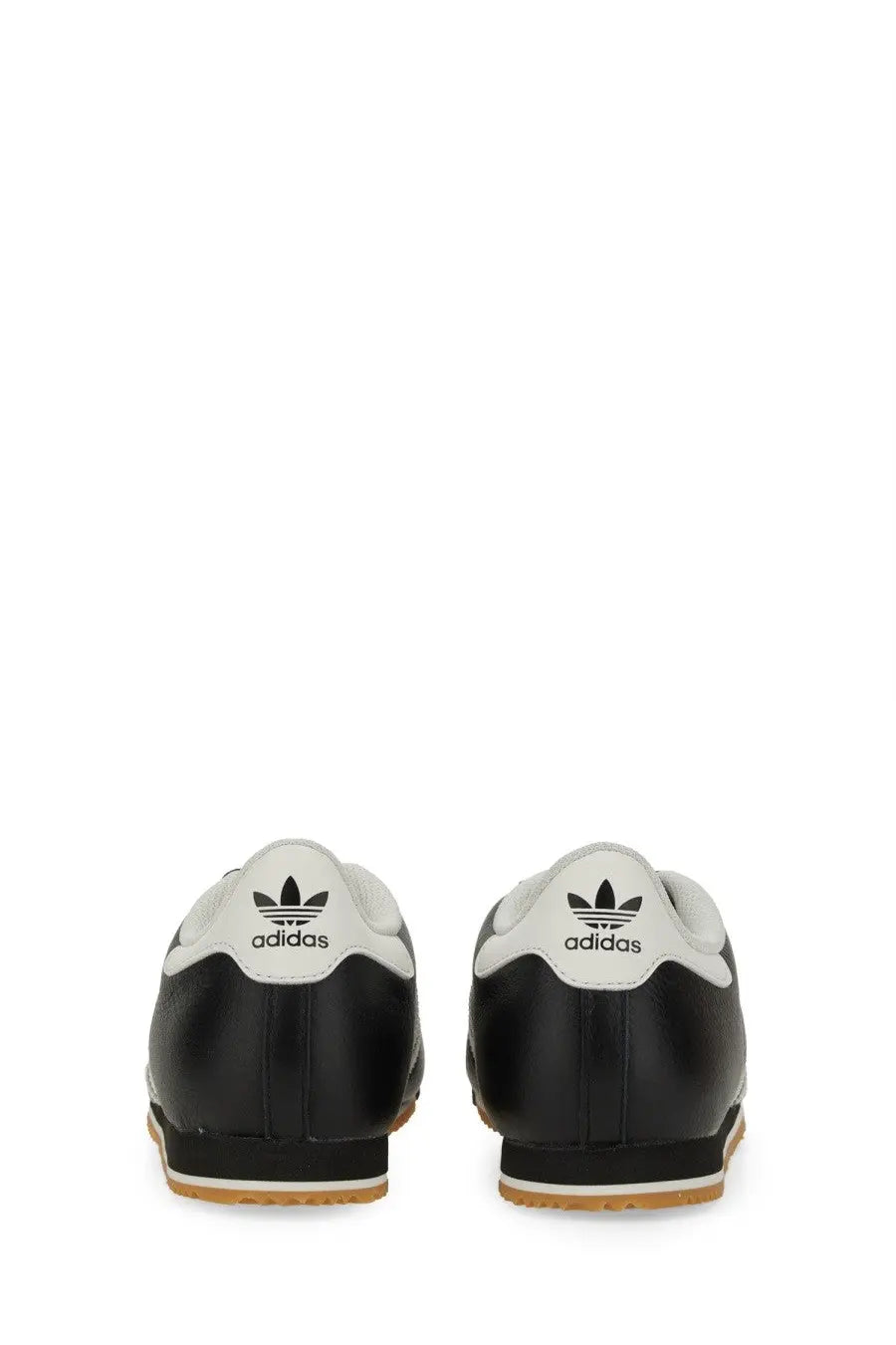 Adidas men’s kick sneaker black showing back side of black and white samba leather upper with trefoil logo heel