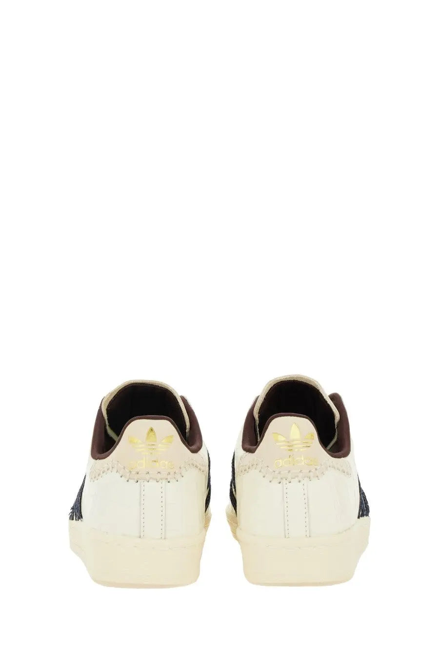 Back view of cream-colored adidas Originals by Wales Bonner men’s sneaker superstar with black stripes and gold trefoil logos