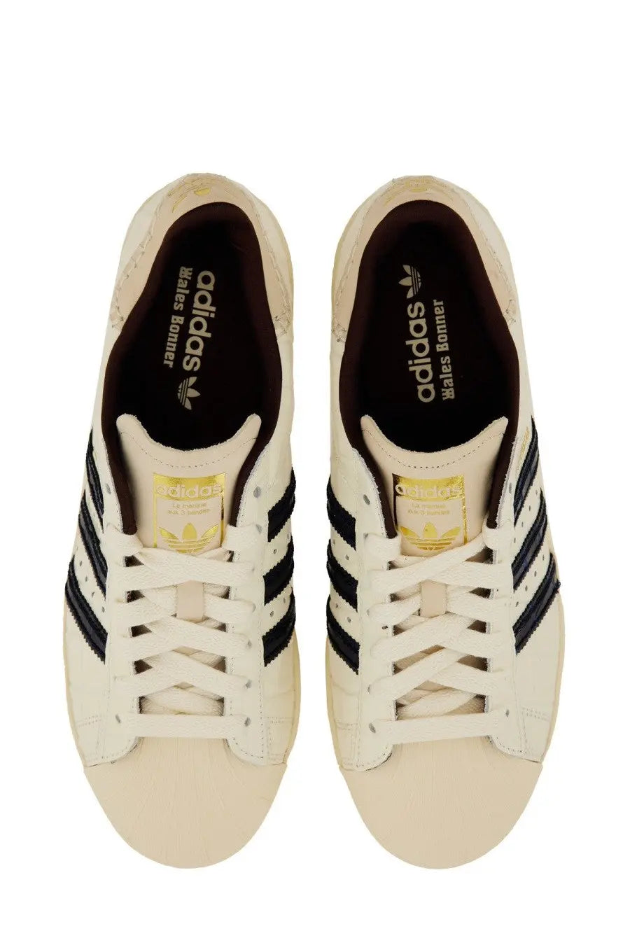 Cream-colored adidas Originals by Wales Bonner men’s sneaker Superstar with black three-stripe stripes and gold branding accents