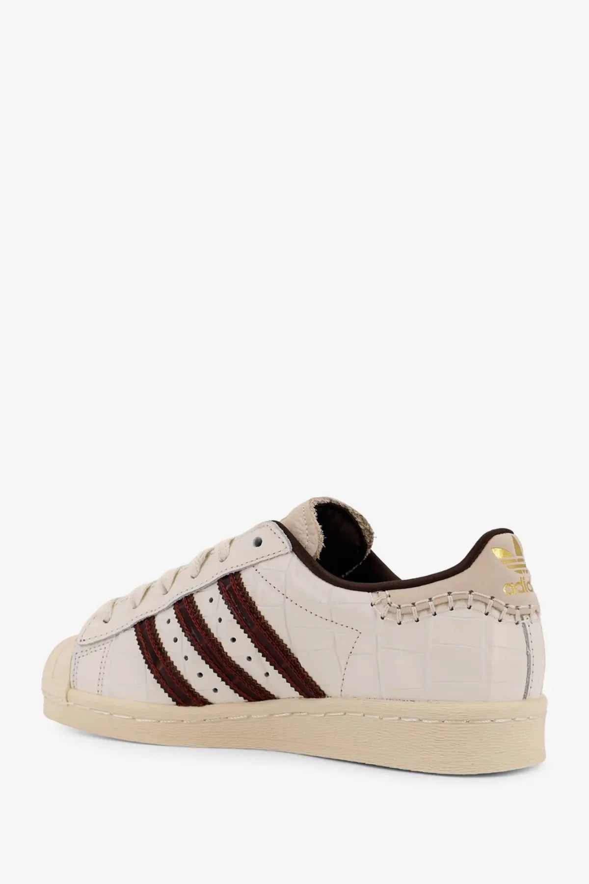 Cream-colored adidas Originals by Wales Bonner men’s WB Superstar leather sneaker with maroon crocodile stripes and gold branding