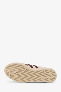 Cream-colored adidas originals by wales bonner men’s wb superstar leather sneakers with maroon stripes and herringbone sole
