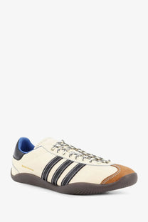 Cream-colored adidas Originals by Wales Bonner unisex WB Karintha OG leather sneaker with black stripes and blue collar lining