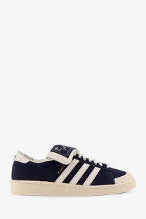 Navy blue adidas superstar sneakers with white stripes and cream rubber sole from adidas Originals x Willy Chavarria