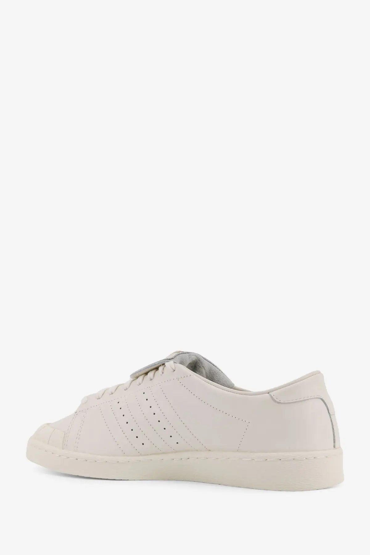 Cream-colored leather adidas Originals x Willy Chavarria men’s low top sneakers with three-stripe design and rubber toe cap