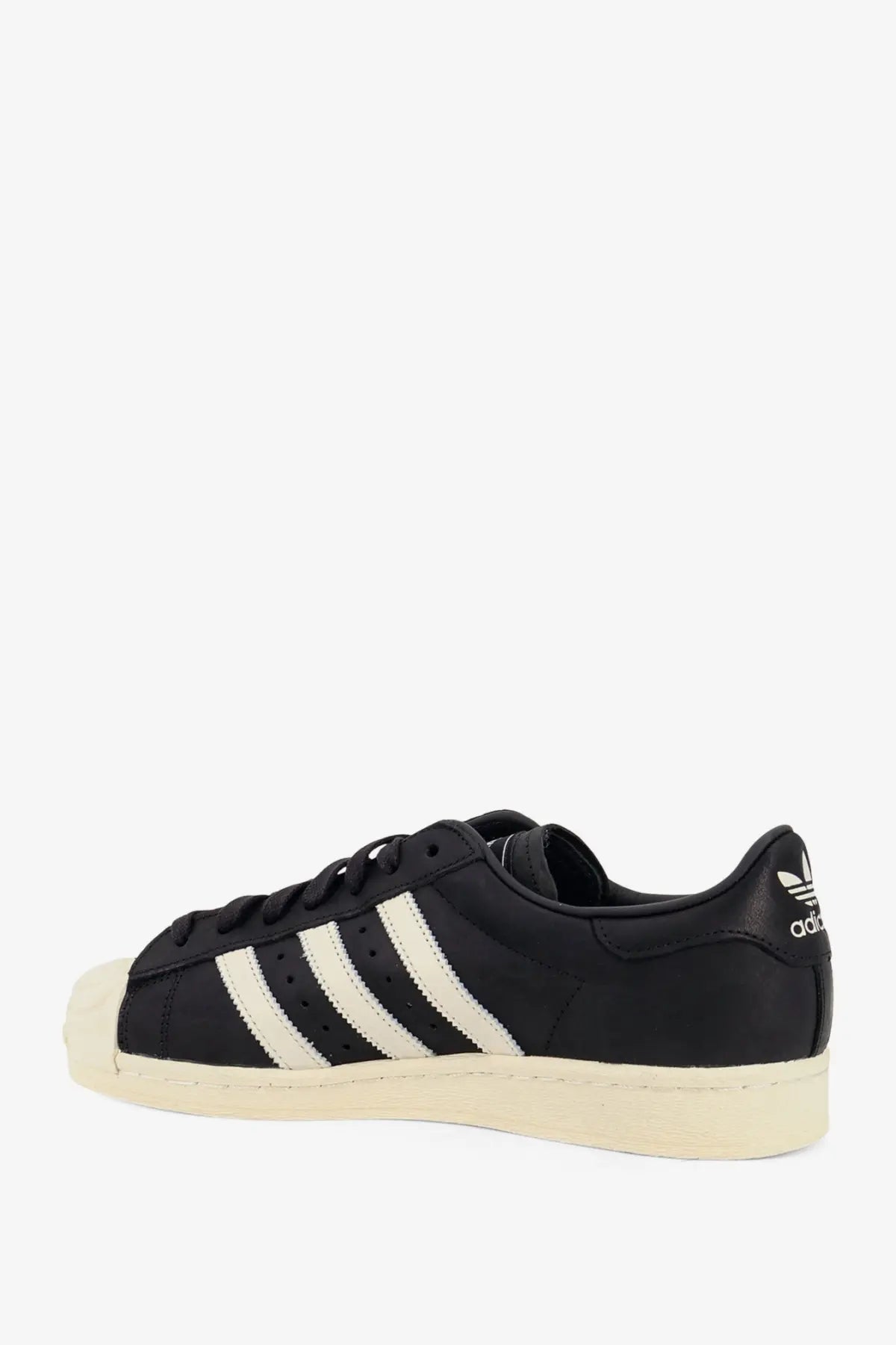 Black adidas originals x willy chavarria men’s leather superstar sneaker with three white stripes and cream rubber toe cap