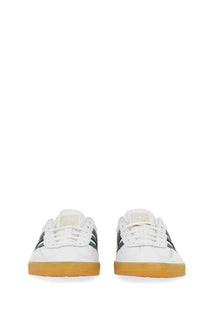White adidas unisex gazelle indoor shoe with dark green stripes and gum-colored rubber sole