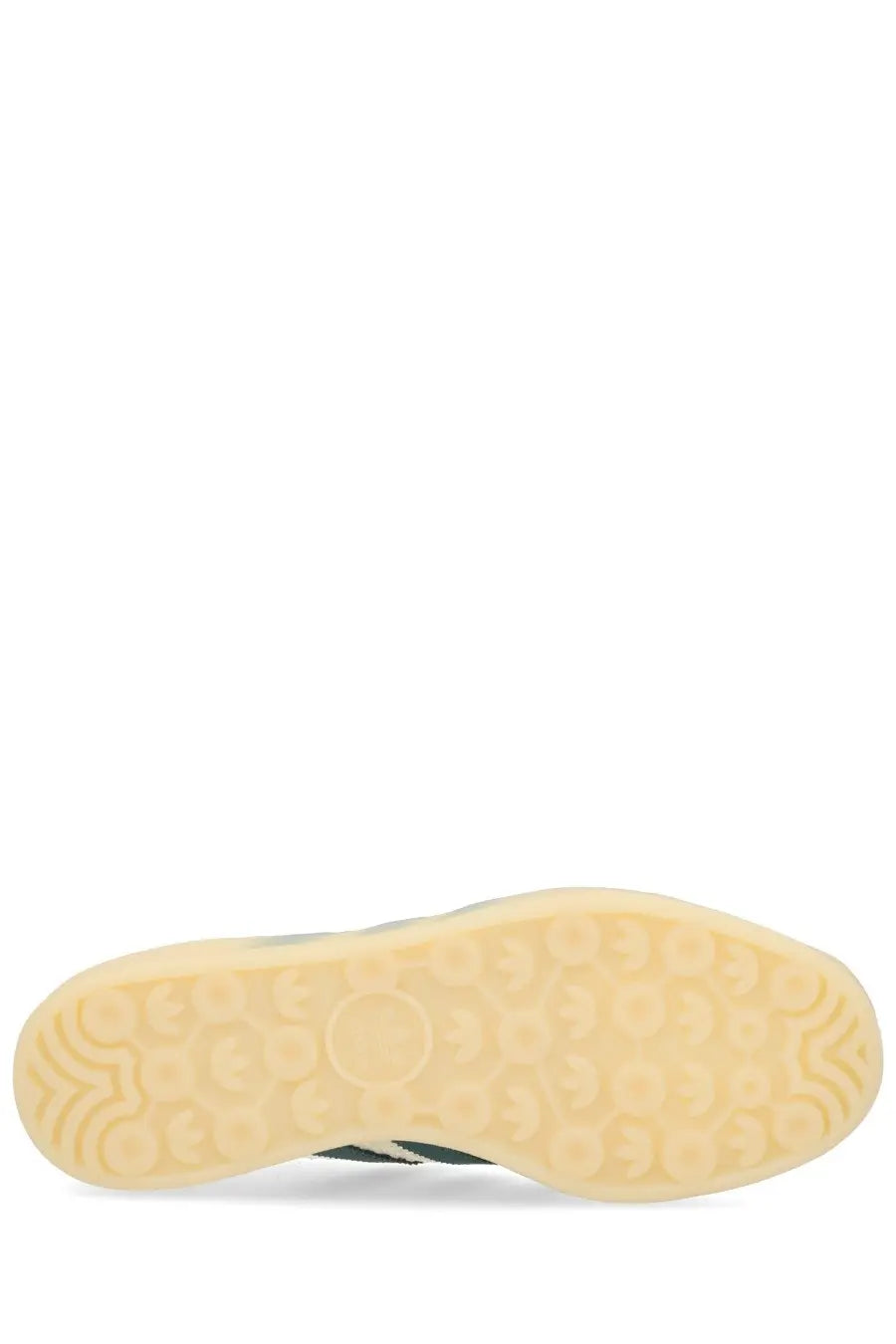 The sole of a beige rubber adidas unisex gazelle indoor sneaker with textured pattern and green edge accents