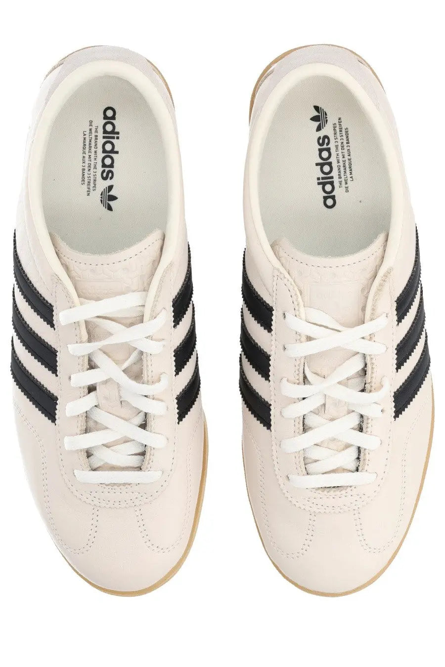 Cream-colored adidas unisex gazelle lo pro sneaker with black three stripes and white laces in beige tone