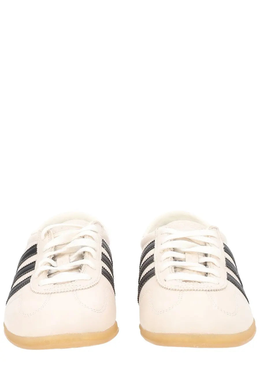 White adidas unisex gazelle lo pro sneaker with black three stripes and tan rubber sole in beige color