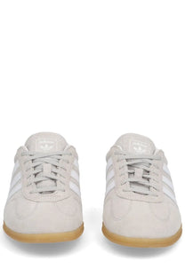 Light gray suede adidas unisex gazelle lo pro sneaker with white stripes and gum rubber sole