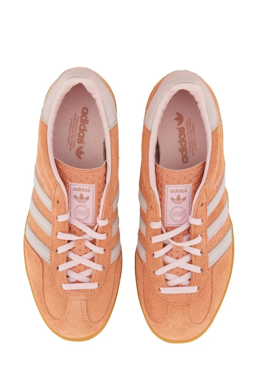 Pair of peach suede adidas unisex indoor Gazelle sneakers with white laces and three stripes