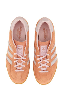 Pair of peach suede adidas unisex indoor Gazelle sneakers with white laces and three stripes