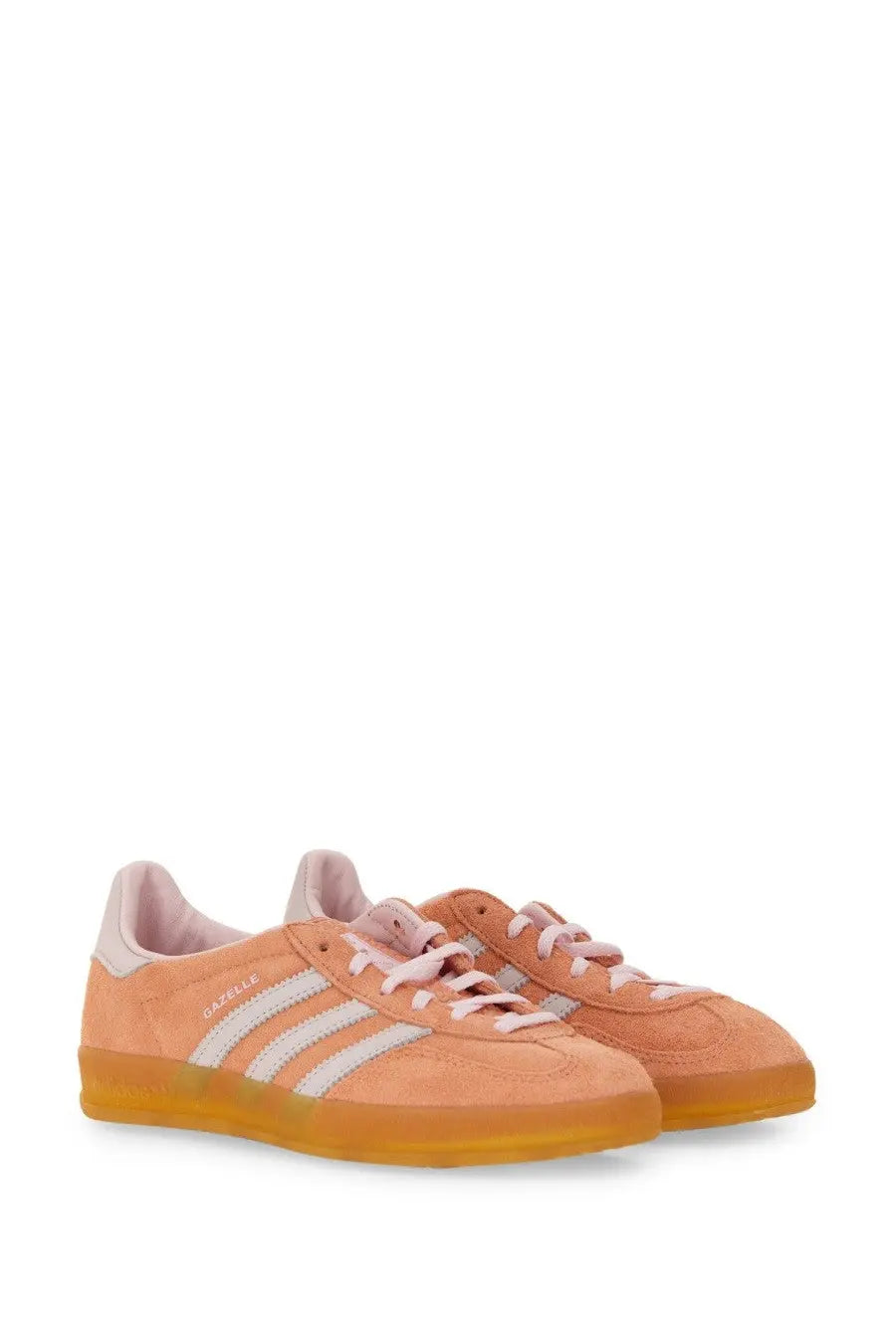 Peach-colored suede adidas gazelle unisex indoor sneaker with white stripes and pink laces