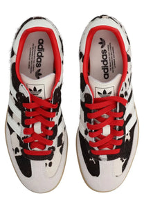 White adidas unisex samba OG sneaker with black splatter paint design vibrant red laces and iconic three stripes