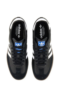 Black adidas unisex samba sneaker featuring white stripes and blue branding accents in a classic leather design