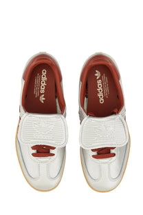 White leather adidas unisex samba sneaker with red accents and velcro strap for casual wear