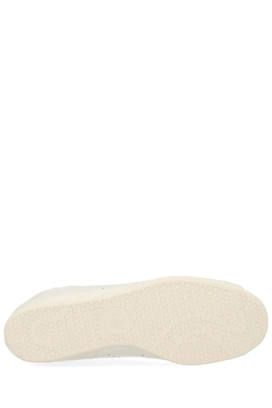 White rubber textured sole of adidas unisex stan smith lo pro sneaker in white showing patterned surface