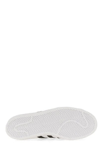 Back side of adidas unisex superstar sneaker with white rubber sole wavy tread and three black stripes on the heel