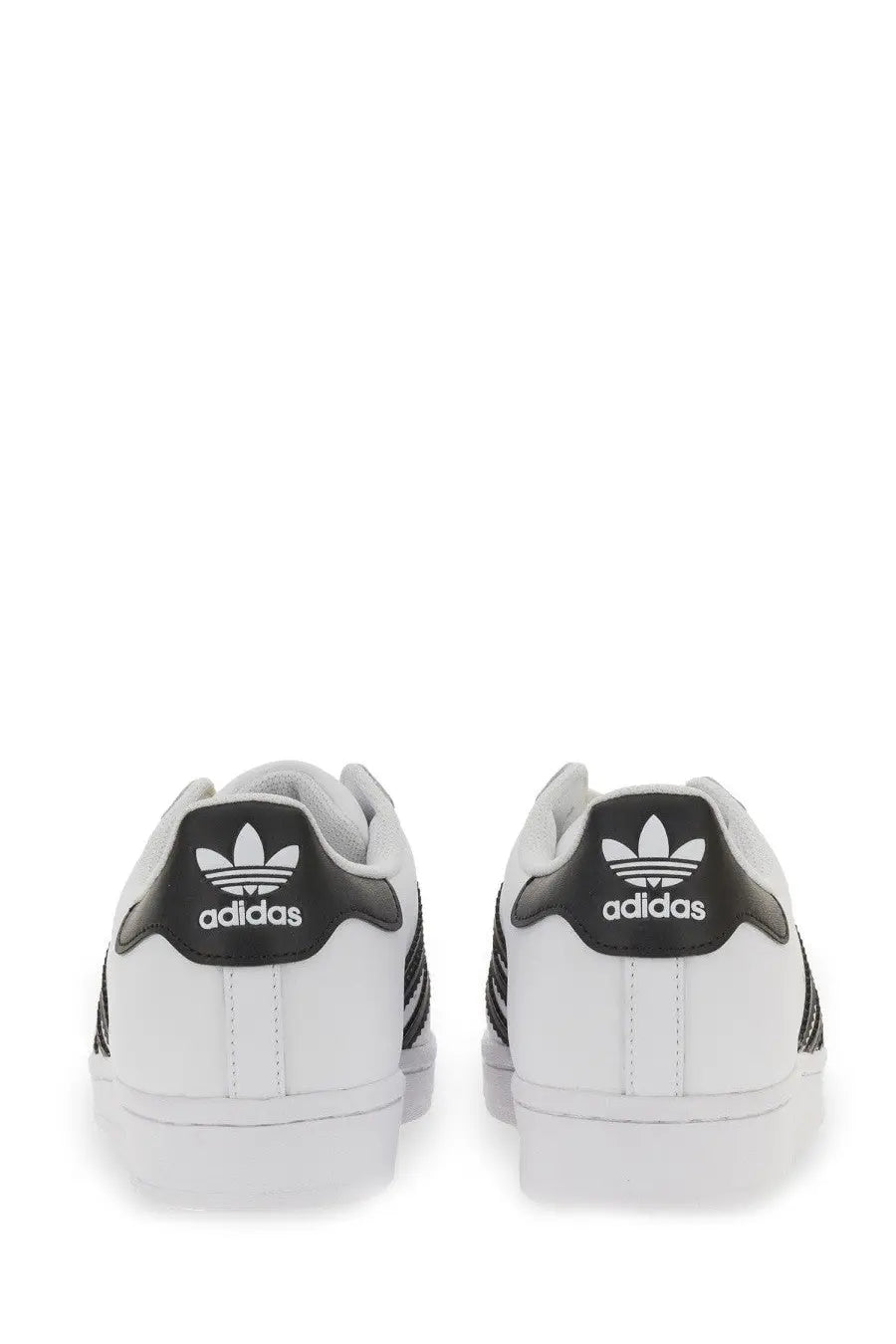 White adidas unisex superstar sneaker showing back side with black leather accents and trefoil logo on heel