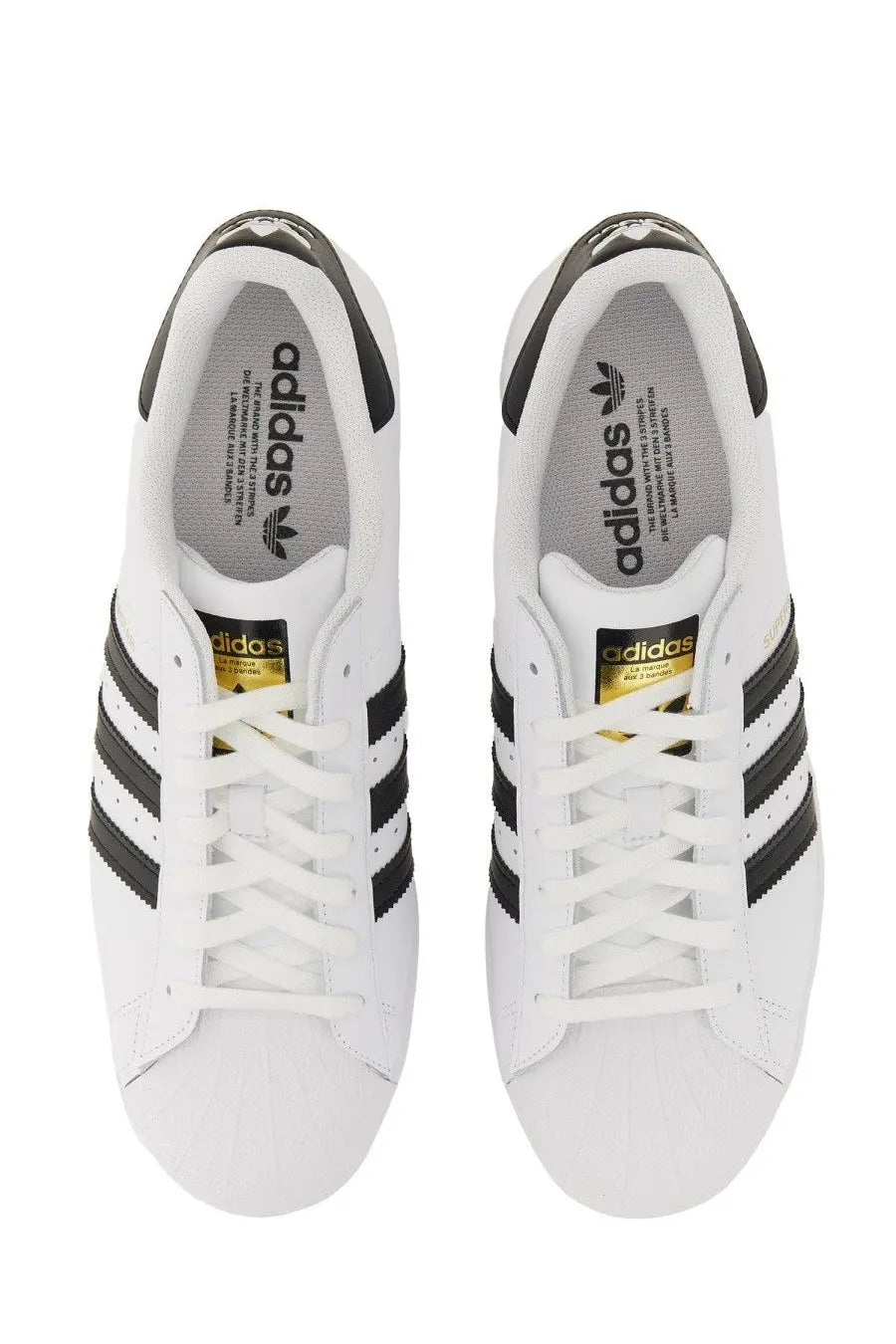 White adidas unisex superstar sneaker featuring black three stripes and gold branding accents in leather design