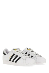 White adidas unisex superstar sneaker with black three stripes and gold branding accents in leather material