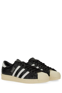 Adidas unisex superstar vintage sneaker in black croc embossed leather with white stripes and cream rubber sole