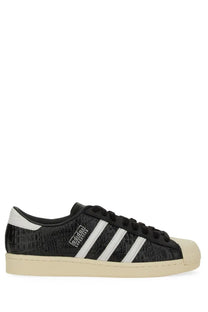 Black adidas unisex superstar vintage sneaker with textured crocodile-embossed upper white three stripes and rubber toe cap