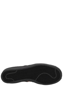 Black rubber sole with herringbone tread pattern on adidas unisex superstar vintage sneaker in red