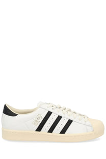 Adidas unisex superstar vintage sneaker in white leather with black three stripes and cream rubber toe cap
