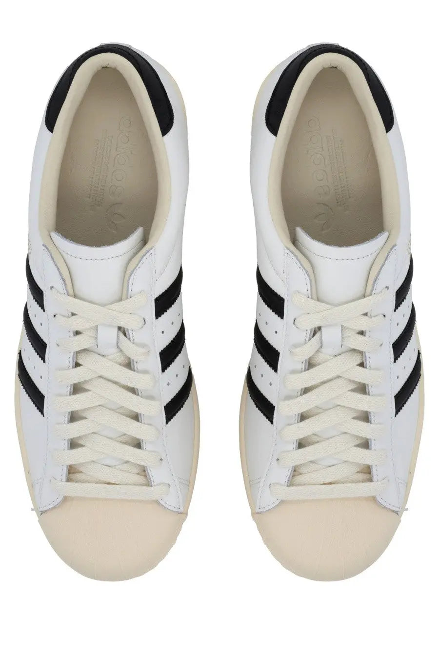 White leather adidas unisex superstar vintage sneaker with black three stripes and cream rubber toe caps