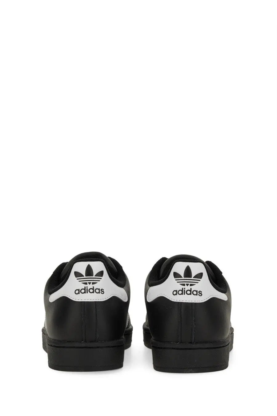 Black adidas unisex superstar sneaker showing back side with white rubber toe caps and trefoil logo on heel