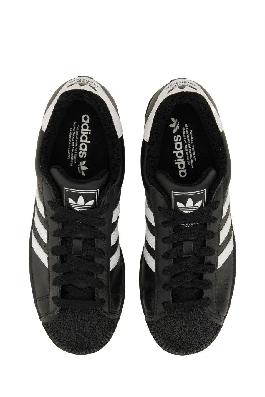 Black adidas unisex superstar sneaker with white three-stripe detailing and textured rubber toe cap