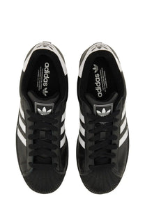 Black adidas unisex superstar sneaker with white three-stripe detailing and textured rubber toe cap