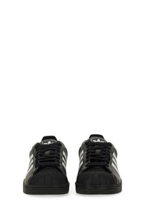 Black adidas unisex superstar sneaker with white three-stripe detailing and textured upper material