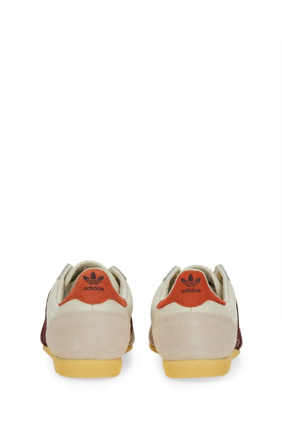 Cream-colored suede adidas women’s sneaker japan white with orange heel tabs and yellow rubber soles back view