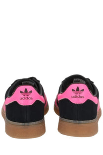 Adidas women’s sneaker Muenchen black in black and neon pink with a gum-colored rubber sole for casual wear