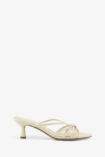 Aeyde women’s Abby cream-colored leather mule sandal with slender heel and crisscross straps in white