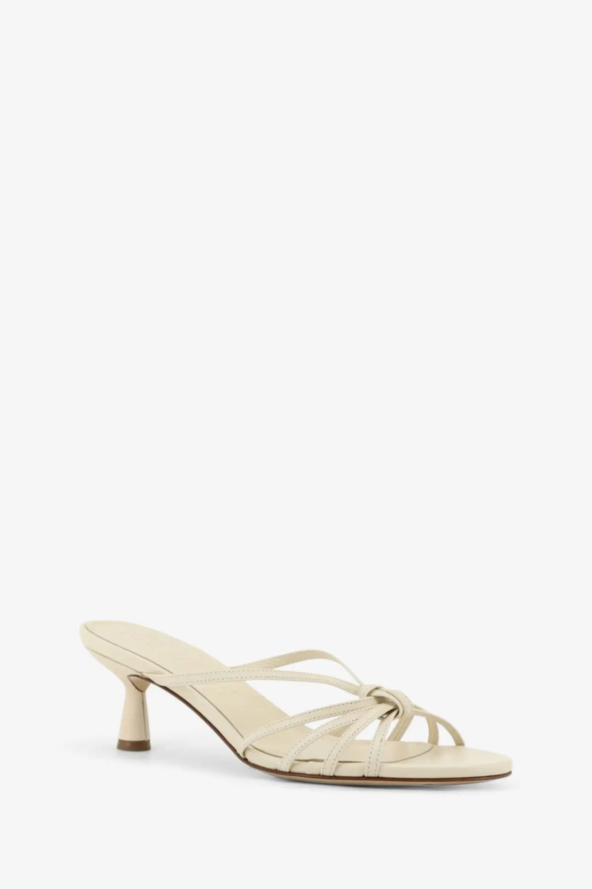 Cream-colored leather mule sandal with slender heel and crisscross straps from Aeyde women’s Abby collection white