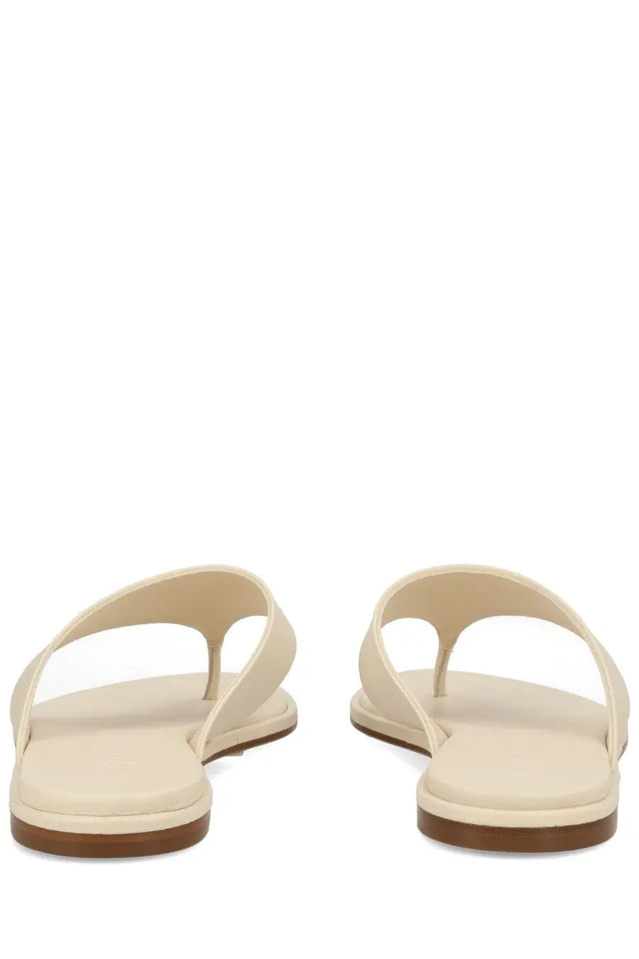 Aeyde women’s cream-colored leather thong sandal with flat sole and brown rubber heel in white
