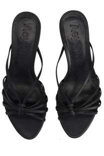 Black leather aeyde sandals with crisscross straps and a tied bow at the front.