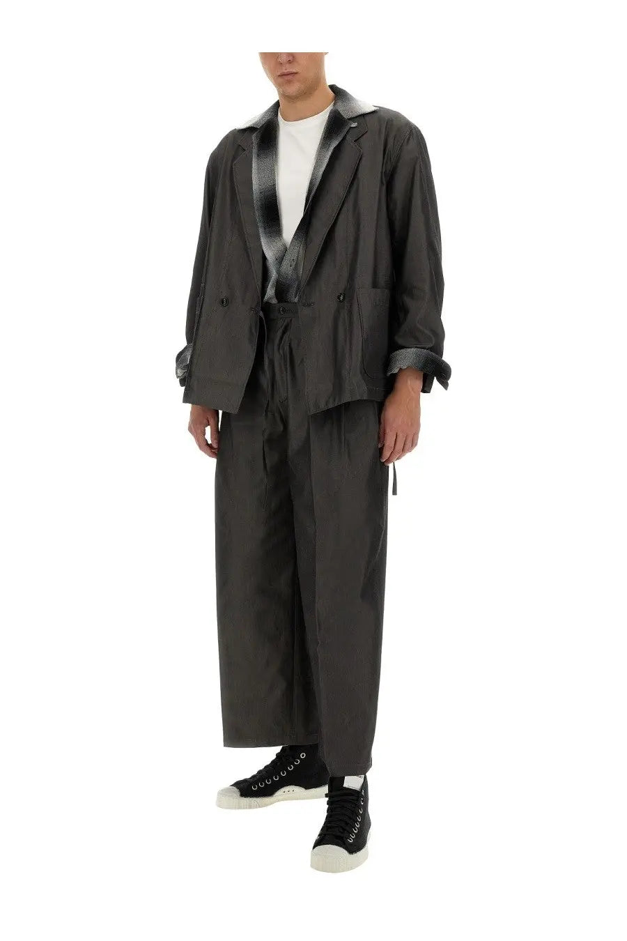 Dark gray trench coat with subtle sheen and black and white striped inner lining paired with aïe men’s wide fit grey pants